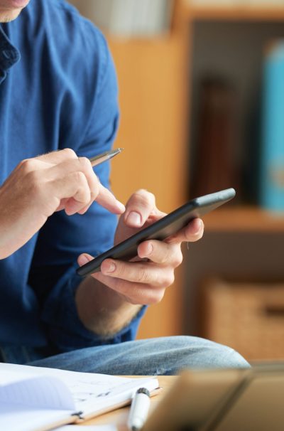 Hands of businessman with pen in his hand texting